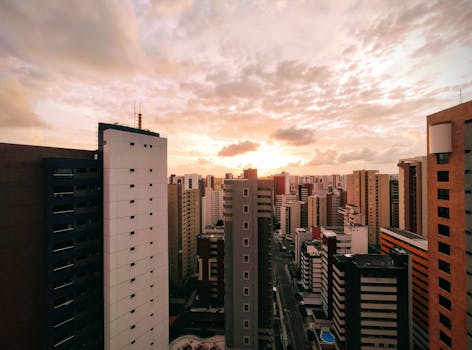 A stunning urban skyline view captured at sunset with a golden sky and modern skyscrapers.