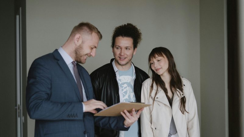 Happy couple meeting with a real estate agent discussing paperwork indoors.